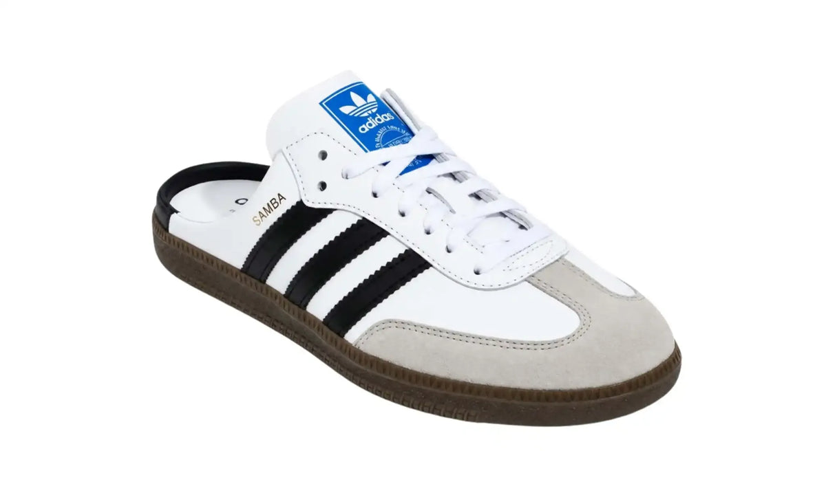 Adidas Samba OG Mule Cloud White angled view with black stripes, grey T-toe overlay, white laces, blue tongue label, open heel and dark gum-coloured sole
