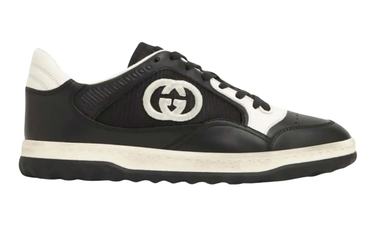 Side view of black Gucci GG low-top sneakers with ivory logo, heel tab and midsole