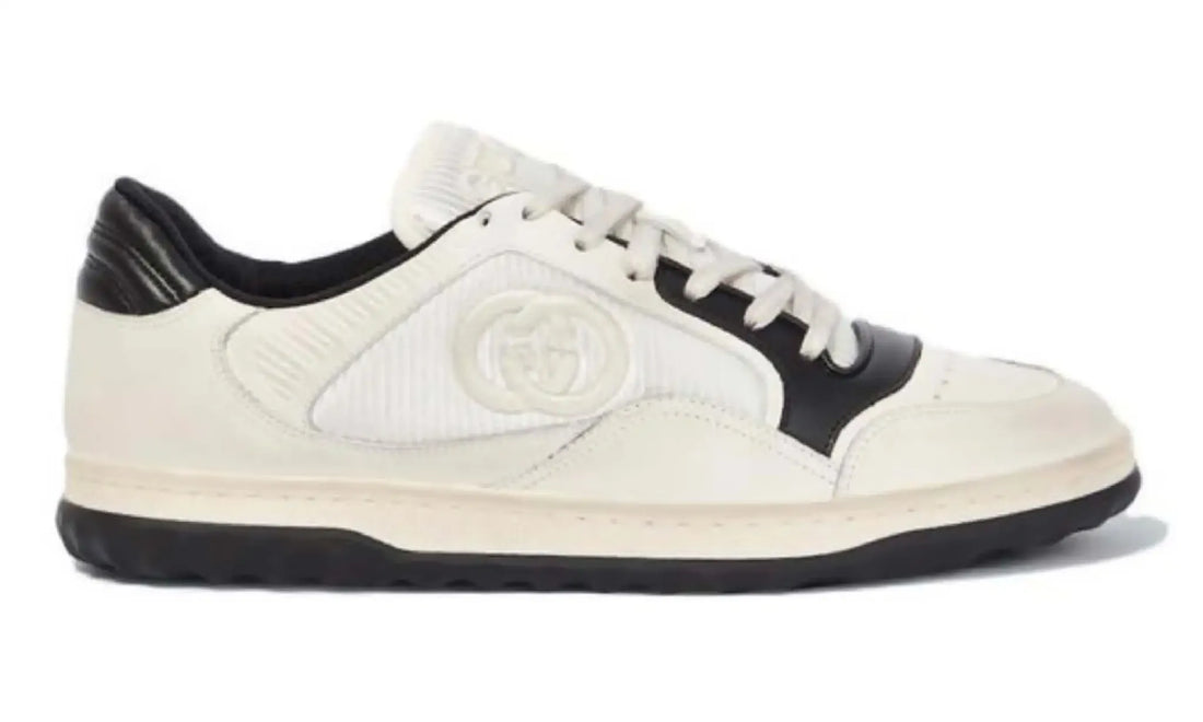 Side view of Gucci GG low-top sneakers in ivory and black with cream laces and textured panels