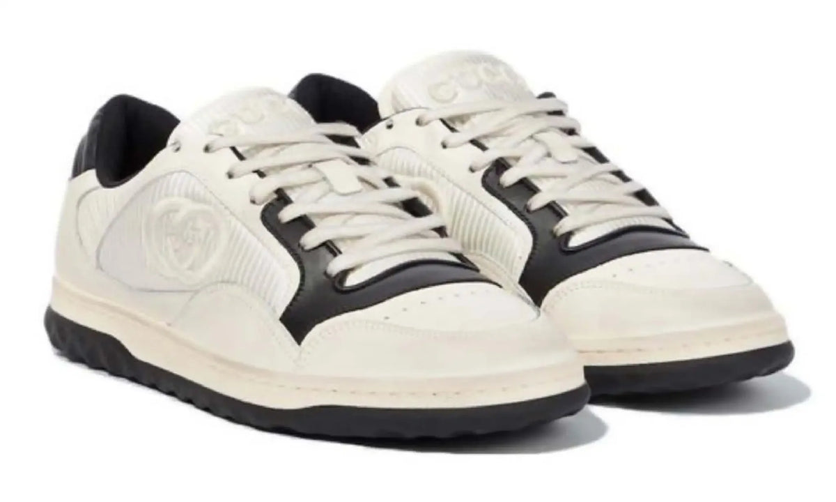 Front angled view of Gucci GG ivory and black sneakers with cream laces