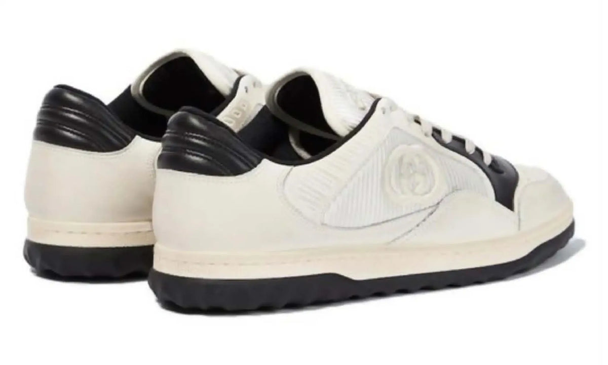 Rear angled view of Gucci GG ivory and black sneakers showing black heel panels