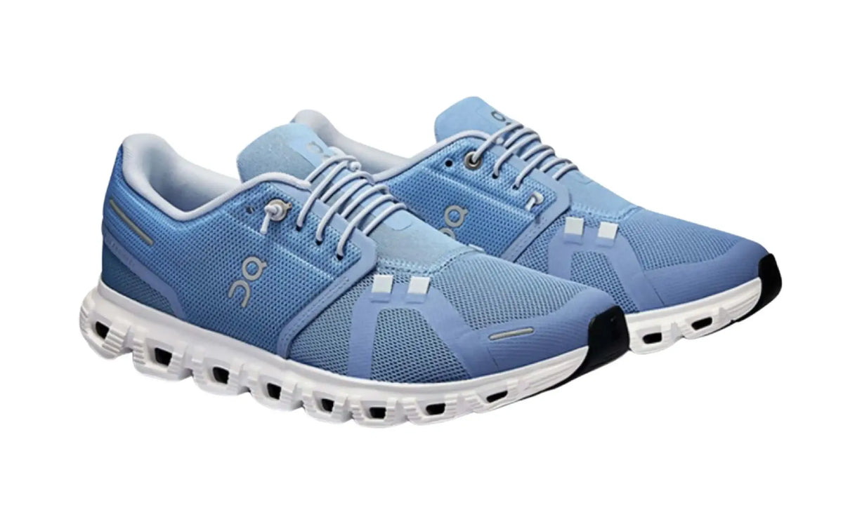 Pair of On Cloud 6 Light Blue White unisex sneakers, angled front view showing laces and white soles