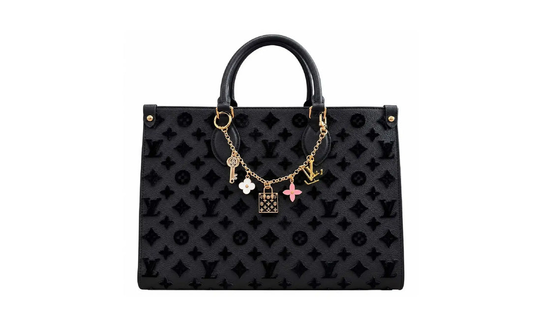 Front view of Black OnTheGo MM monogram tote bag with gold-tone charm chain and top handles