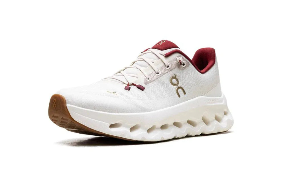 White athletic shoe with red accents on a white background